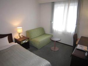 um quarto de hotel com uma cama e uma cadeira em Ichihara Marine Hotel - Vacation STAY 01363v em Ichihara