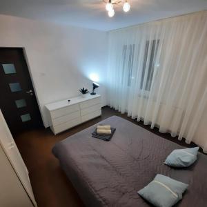a bedroom with a bed and a dresser and a window at Apartament KEPA din Piatra Neamt in Piatra Neamţ