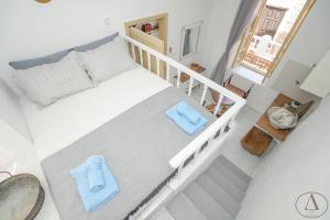 1 dormitorio con 1 cama grande y toallas azules. en Mansion House(est.c1890)-Daedalus, en Halki