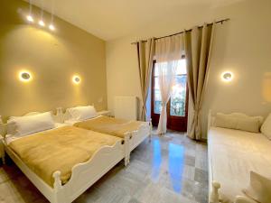 een slaapkamer met 2 bedden en een raam bij Hermes Hotel in Mithimna