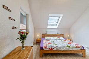 a bedroom with a bed and a vase of flowers on a table at Leppert in Schwanau