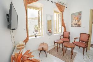 Una sala de estar con dos sillas y un televisor. en Mansion House(est.c1890)-Daedalus, en Halki