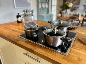 two pots on top of a stove in a kitchen at Spacious 4 Bedroom Farmhouse in Pembrokeshire +56 photos
