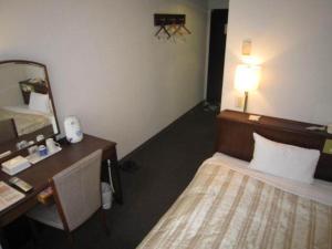 ein Hotelzimmer mit einem Bett, einem Schreibtisch und einem Spiegel in der Unterkunft Ichihara Marine Hotel - Vacation STAY 01349v in Ichihara