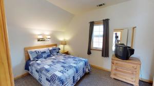 a bedroom with a bed and a tv on a dresser at Wiggins River Retreat 5 On The River in Red River