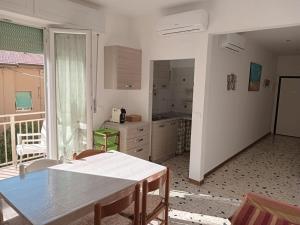 eine Küche mit einem Tisch und einer Arbeitsplatte in der Unterkunft Brezza Marina a 30 mt dalla spiaggia in Marina di Castagneto Carducci