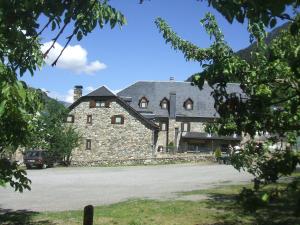 un grand bâtiment en pierre avec une voiture garée devant. dans l'établissement Hotel Casa Estampa, à Escuñau