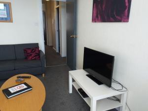 een woonkamer met een tv op een witte tafel bij Cricket Stadium View in Scarborough