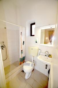 een badkamer met een toilet, een wastafel en een douche bij Hermes Hotel in Mithimna