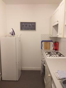 een keuken met een witte koelkast en een fornuis bij Cricket Stadium View in Scarborough