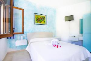 - une chambre avec un grand lit blanc et un miroir dans l'établissement B&B Carmela, à Torre Dei Corsari