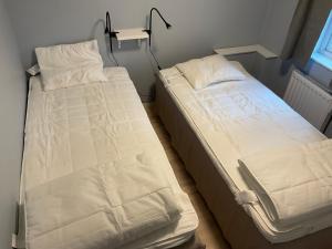 dwa łóżka siedzące obok siebie w pokoju w obiekcie Högklint Rövar Liljas Apartment w mieście Visby