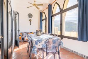 una sala da pranzo con tavolo, sedie e finestre di Petit Palau a Port de Sóller