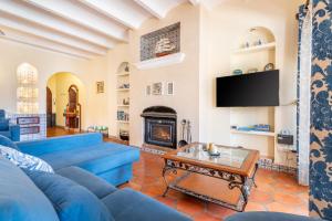 a living room with a blue couch and a fireplace at Petit Palau in Port de Soller