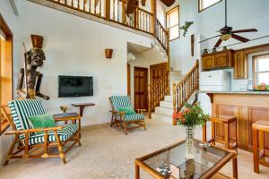 a living room with two chairs and a table at Villa 99-Beachfront-Pool-Luxury Villa in Placencia