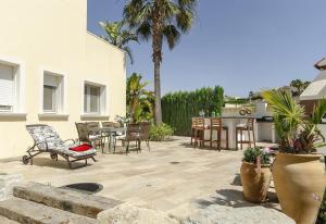 eine Terrasse mit Stühlen, einem Tisch und einer Küche in der Unterkunft Vista Panorámica in Benitatxell