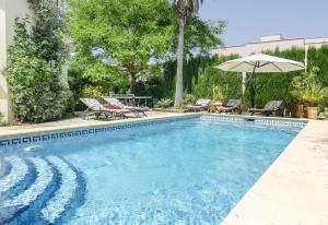 ein Swimmingpool mit zwei Stühlen und einem Sonnenschirm in der Unterkunft Vista Panorámica in Benitatxell