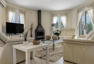 ein Wohnzimmer mit weißen Möbeln und einem Kamin in der Unterkunft Vista Panorámica in Benitatxell