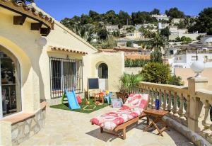 a patio with a couch and a table on a balcony at La Vista in Moraira