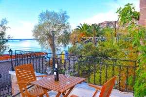 a table and chairs on a balcony with a view of the water at Hermes Hotel in Mithymna