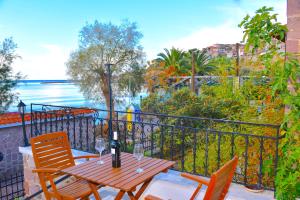 een tafel en stoelen op een balkon met uitzicht op het water bij Hermes Hotel in Mithimna