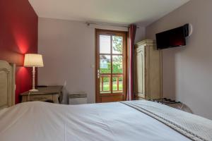 a bedroom with a white bed and a window at Hotel Village Motel in Tournus