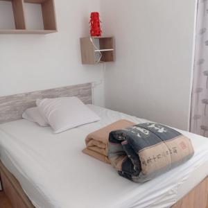 a bedroom with a bed with white sheets and a pillow at Empuriabrava Vue Mer in Empuriabrava