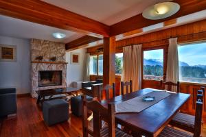 uma sala de jantar com uma mesa e uma lareira em Bustillo 7500 em San Carlos de Bariloche