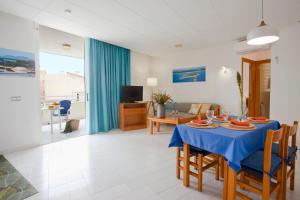 uma sala de jantar e sala de estar com uma mesa azul em Apartamento Es Trenc 1 em Colonia Sant Jordi
