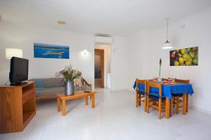 uma sala de estar com uma mesa de jantar e uma televisão em Apartamento Es Trenc 1 em Colonia Sant Jordi