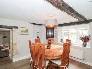 a dining room with a wooden table and chairs at Long Cottage in Bath
