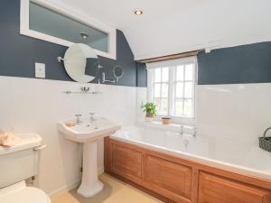 a bathroom with a white tub and a sink at Long Cottage in Bath