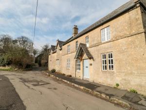 un vieux bâtiment en briques avec une porte blanche dans l'établissement Long Cottage, à Bath