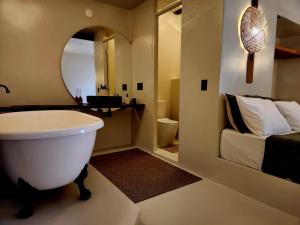 a bathroom with a large white tub and a bed at Outro Beach Hotel Cumbuco in Cumbuco