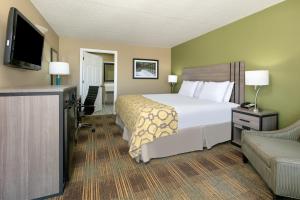 a bedroom with a bed and a desk and a television at Baymont by Wyndham Prattville - Montgomery in Prattville