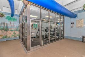 een fitnessruimte met glazen deuren en loopbanden bij Beach Colony Resort Unit 1405 - Beautiful Oceanfront Condo - 1 bedroom, 1 bath - Perfect for 6! in Myrtle Beach