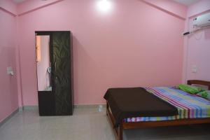 a bedroom with a bed and a pink wall at chill out home morjim in Morjim