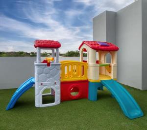 a toy playground with a playset on the grass at Elegante y fino departamento a estrenar! in La Mercedes