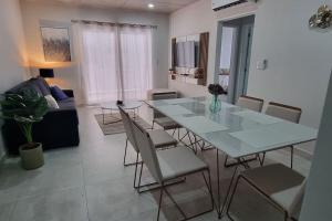 a dining table and chairs in a living room at Elegante y fino departamento a estrenar! in La Mercedes