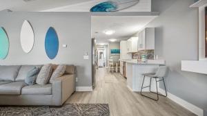 a living room with a couch and a kitchen at Blue Neptune at 5313 Sunset Avenue by Nautical Properties Vacation Rentals in Panama City Beach