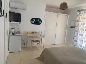 a bedroom with a bed and a table and a kitchen at Les Palmiers in Le Muy