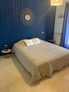a blue bedroom with a bed and a fan at Les Palmiers in Le Muy