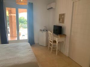 a bedroom with a desk with a computer and a television at Les Palmiers in Le Muy