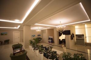 una sala de estar con plantas y una lámpara de araña en Tashkent Hotel, en Nukus
