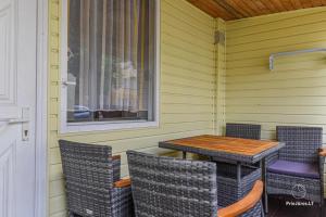 a table and chairs on the porch of a house at RAMYBĖS OAZĖ 2 in Šventoji