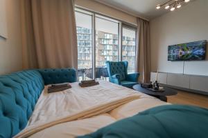 1 dormitorio con 1 cama grande y 2 sillas azules en The View 01.10 - Quartier Belvedere en Viena