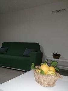een fruitmand op een tafel naast een bank bij La casetta del Fico d'India in Marsala +19 foto's