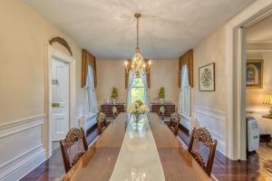 a dining room with a long table and chairs at Monroe Manor Inn in South Haven