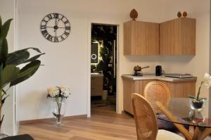 a kitchen with a table and a clock on the wall at Flat with Jacuzzi - Casa Pia in Mondello