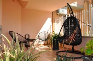 a patio with chairs and plants and a bag at Flat with Jacuzzi - Casa Pia in Mondello